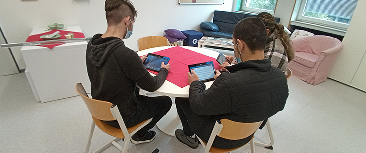 Drei Lernende in Bibliothek