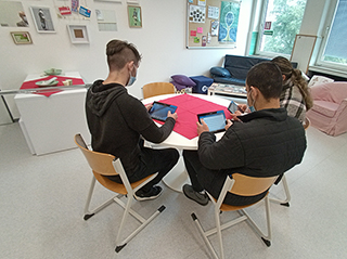 Drei Lernende mit Tablets in der Bibliothek, Foto: Winfried Altmann